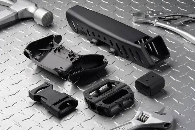 Black 3D printed parts on a metal background