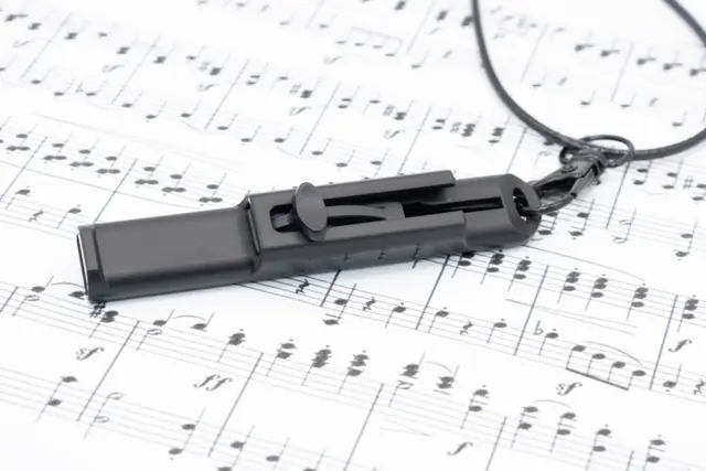 Black Vocal Trainer on top of sheet music